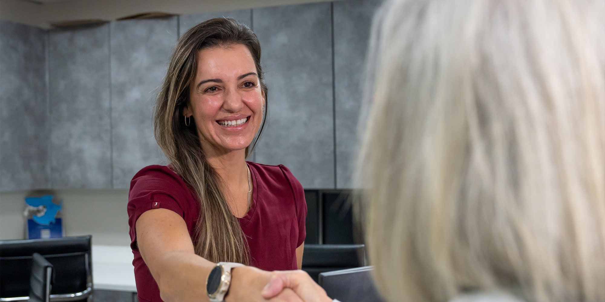 staff member helping patient at the front desk of the dental center
