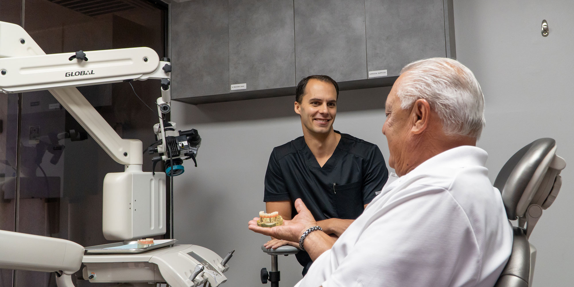 patient holding dental arch model within the dental center with doctor