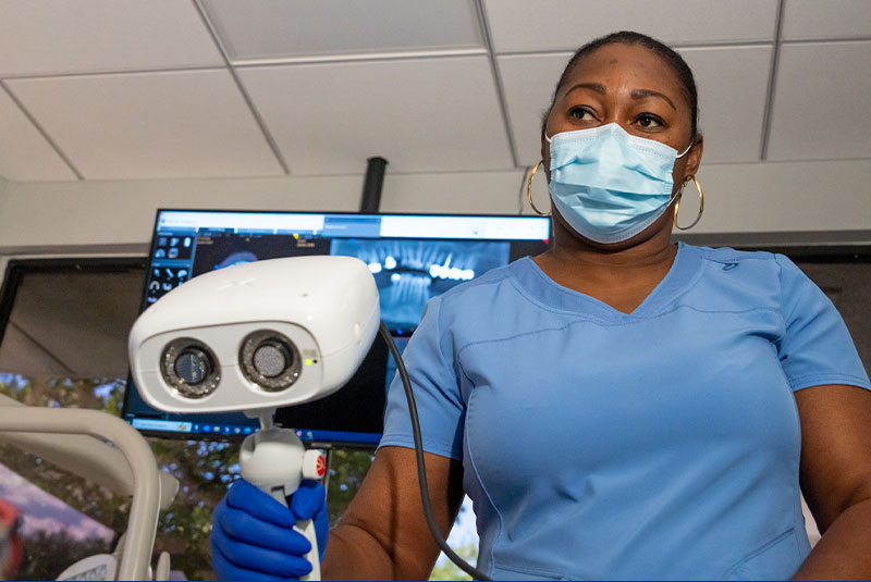 staff member examining dental patient for dental implant procedure