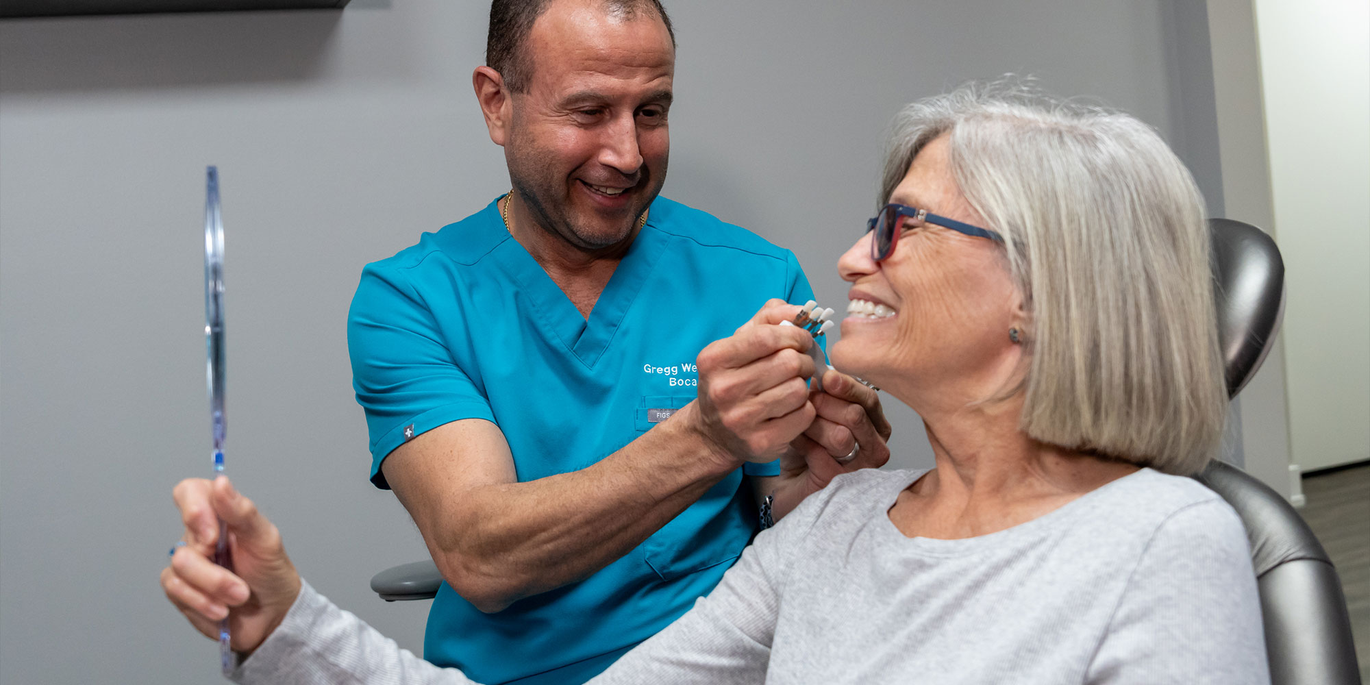 patient and doctor comparing different teeth models